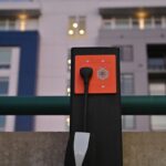 Orange Charger's Level 2 outlet sits installed in an apartment parking lot.