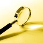 Image of a magnifying glass on a white and yellow background.