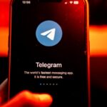 The logo for Telegram Signal messenger application arranged on a smartphone.